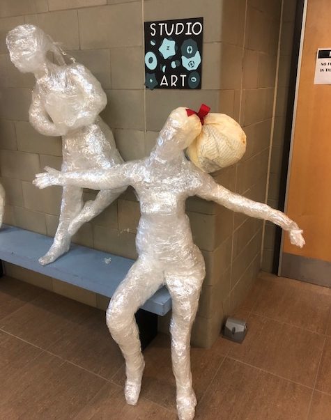 Two life sized statues made of clear tape in the new wing hallway greet you with open arms.