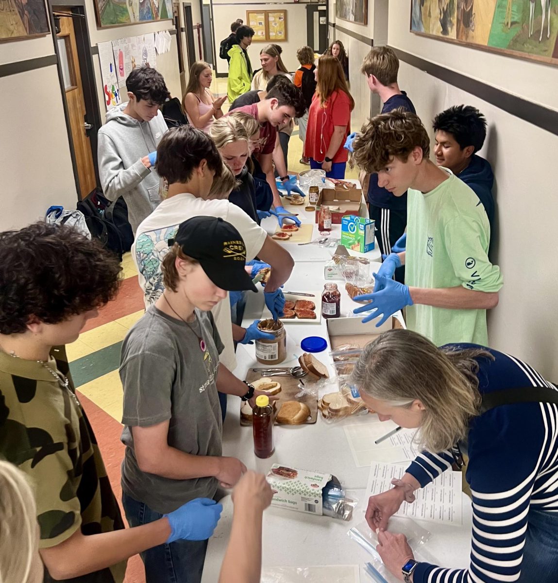 Members of Interact's Sandwich Club, the Crew team and even passersby make a sandwich to contribute to the Blue Fridge in Kingston.