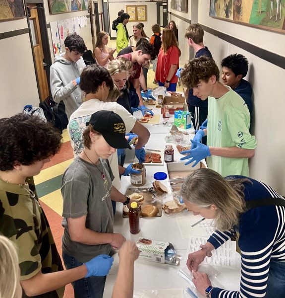 Members of Interact's Sandwich Club, the Crew team and even passersby make a sandwich to contribute to the Blue Fridge in Kingston.